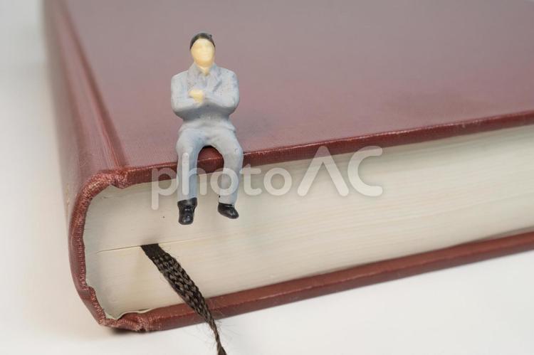 本の上に座る男性 本,読書,学識の写真素材