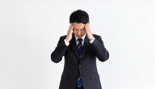 ストレスで顔をおおう日本人ビジネスマン ストレスで顔をおおう日本人ビジネスマンの写真