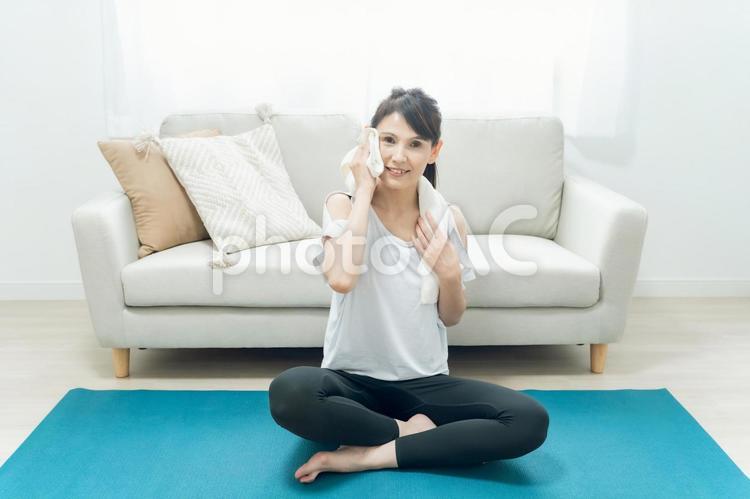 部屋でヨガをする中高年女性（タオル） ホットヨガ,ヨガ,ストレッチの写真素材