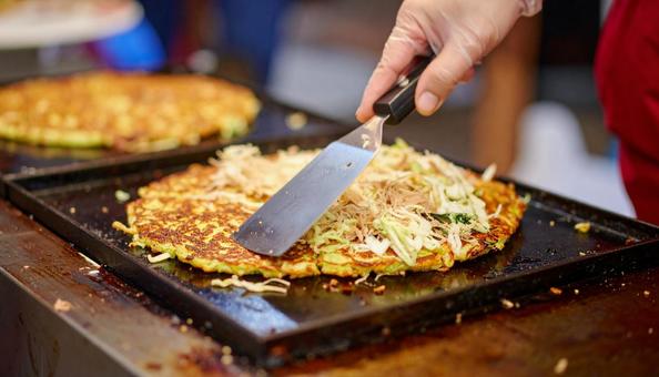 お好み焼きを鉄板で焼く お好み焼きを鉄板で焼くの写真