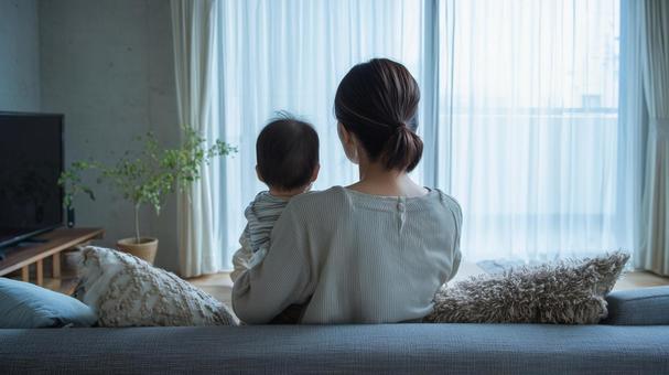 赤ちゃんを抱っこをしている寂しそうな母親 赤ちゃんを抱っこをしている寂しそうな母親の写真