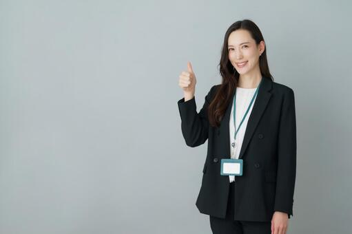 親指を突き出すポーズの若いスーツの女性 女性,good,okの写真素材