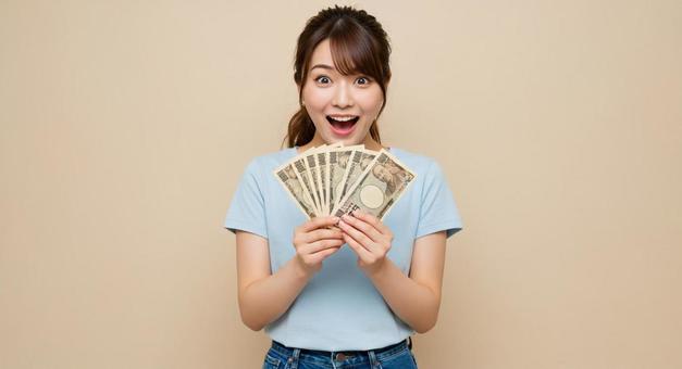 お札を手にして喜ぶ女性 お札を手にして喜ぶ女性の写真