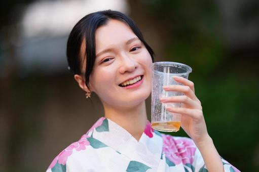 浴衣姿の女性がカップを持って笑う 女性,浴衣,ビールの写真素材
