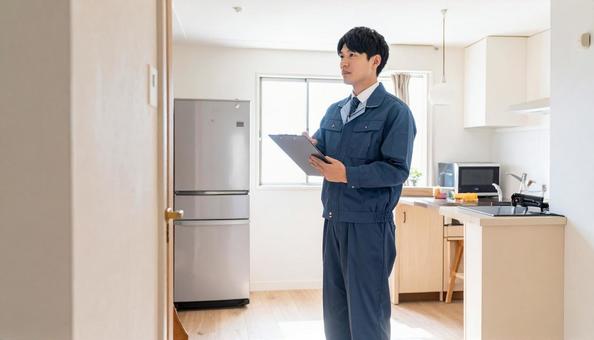 リビング・キッチンを点検する作業服の男性 リビング・キッチンを点検する作業服の男性の写真