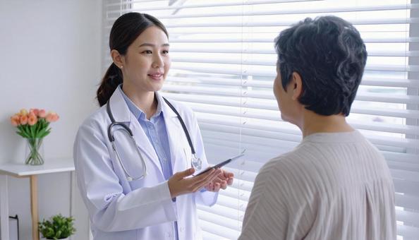 患者女性に説明する日本人医師 患者女性に説明する日本人医師 の写真