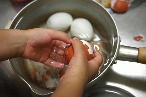 片手鍋に入ったゆで卵の殻をむく子ども 子ども,料理,お手伝いの写真素材