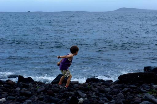 ＜素材＞夏の荒れた海を一人散策する男の子 子供,男性,人物の写真素材