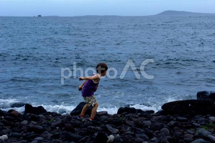 ＜素材＞夏の荒れた海を一人散策する男の子 子供,男性,人物の写真素材