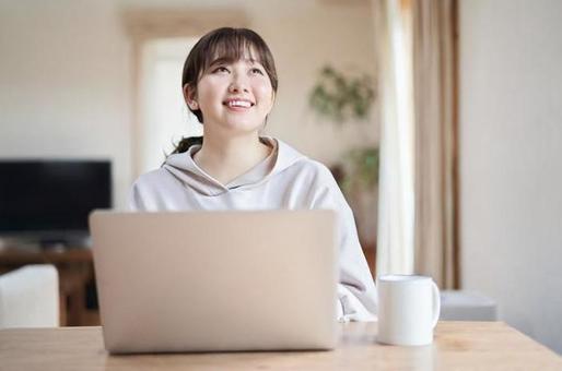 Asian female operating a computer with a smile in the living room, fem, komputer osobisty, uśmiech, JPG