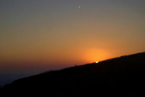 水平線に沈む夕陽と三日月とススキの丘 水平線に沈む夕陽と三日月とススキの丘 夕陽,空,三日月の写真素材