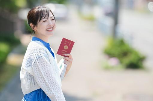 パスポートを持って笑顔の女性 パスポートを持って笑顔の女性 旅,パスポート,旅行の写真素材