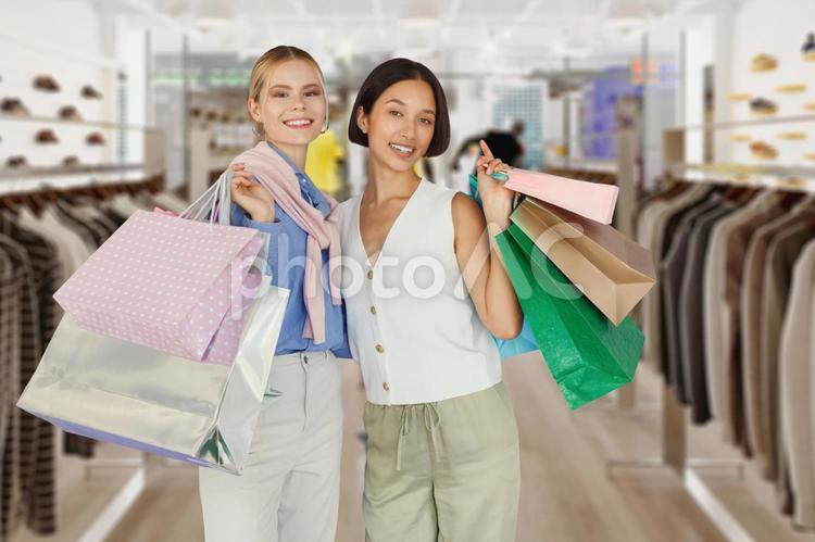 店内でセールで買った物が入ったたくさんの紙袋を持っている2人の女性 セール,ショップ,女性の写真素材
