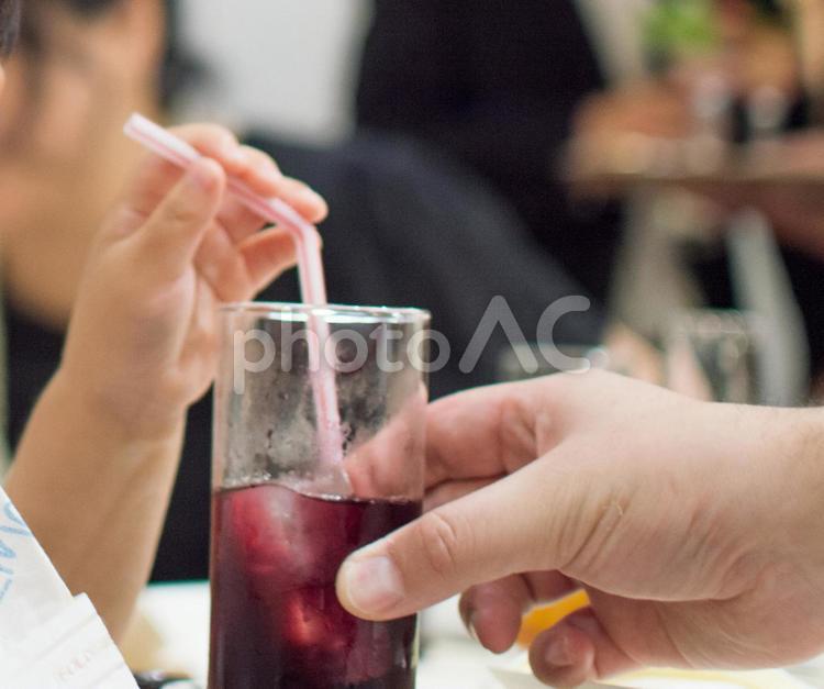 ジュースを渡す親、飲む子供の手 子供,親,手の写真素材