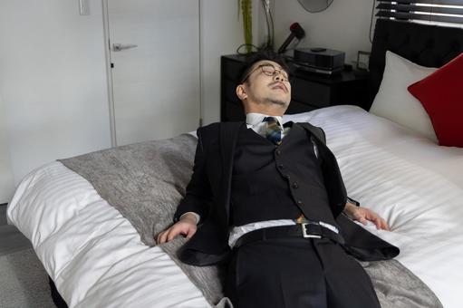 ベッドに倒れ込むビジネスマン ベッドに倒れ込むビジネスマン ビジネスマン,男性,人物の写真素材