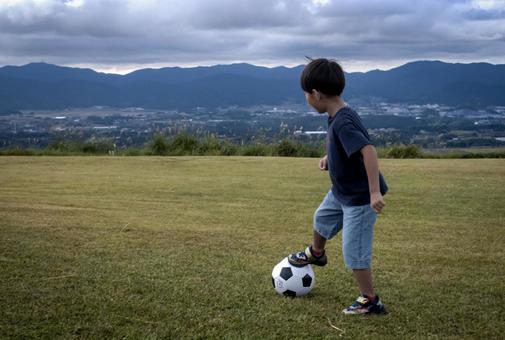 ＜素材＞山頂で元気にサッカーをする男の子 子供,サッカー,運動の写真素材