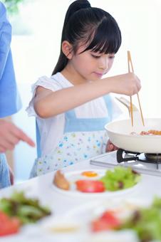 笑顔で朝食の準備をする女の子の写真