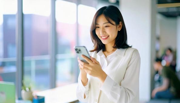スマホを確認するビジネス女性 スマホを確認するビジネス女性の写真
