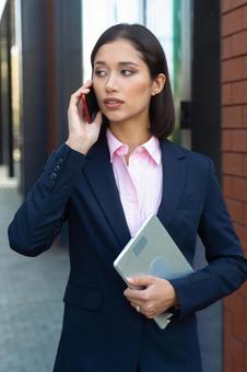 アジア人女性がビジネス街でスマートフォンで電話している ビジネスウーマン,ビジネス,女性の写真素材