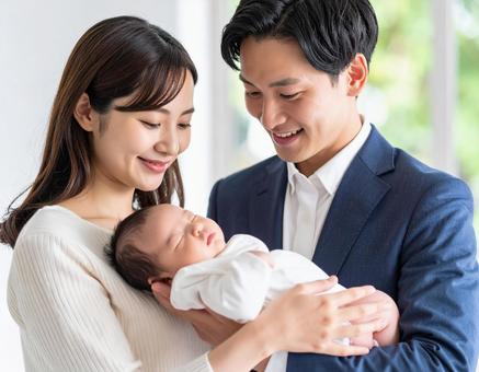 赤ちゃんを抱く幸せそうな夫婦 赤ちゃんを抱く幸せそうな夫婦の写真