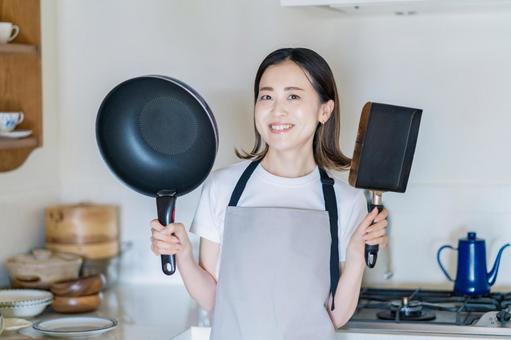 キッチンでフライパンを持つ女性  家事,料理,クッキングの写真素材