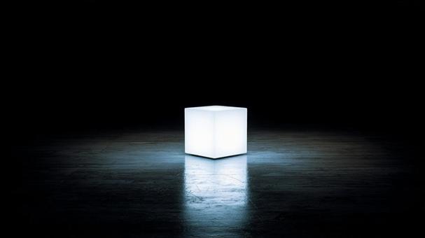 闇に浮かぶ発光立方体の写真