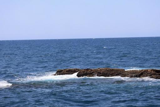 青空と水平線と青い海と岩礁のある風景 青空と水平線と青い海と岩礁のある風景の写真
