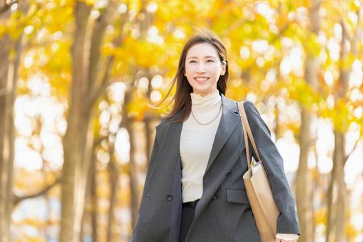 紅葉の街路樹と女性・ビジネスウーマン 女性,秋,紅葉の写真素材