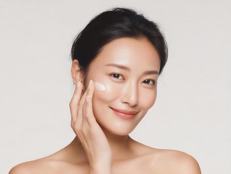 笑顔でスキンケア中の大人の女性の写真