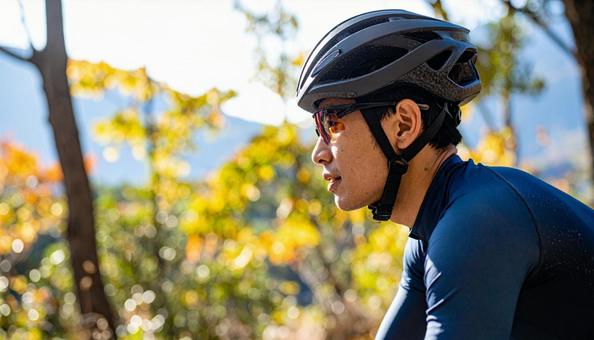 ロードバイクでサイクリングする男性 ロードバイクでサイクリングする男性の写真