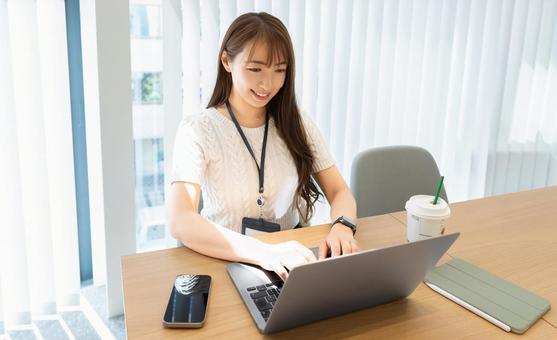 オフィスでパソコンを使う笑顔の女性 オフィスでパソコンを使う笑顔の女性 女性,パソコン,仕事の写真素材