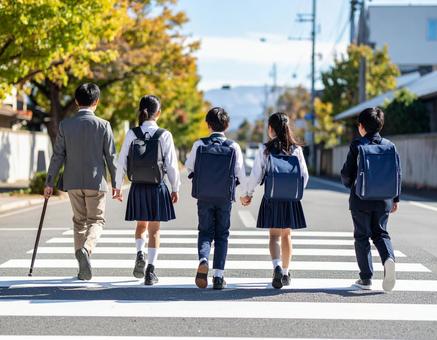 通学中の子供達の後ろ姿 通学中の子供達の後ろ姿の写真