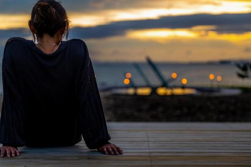 女性一人夕日を眺めている 女性一人夕日を眺めている 女性,一人,夕日の写真素材