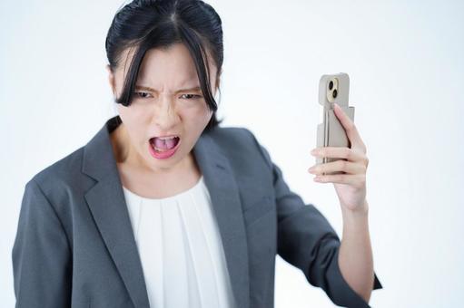 女性がスマートフォンを持って叫ぶ 女性,スマートフォン,持つの写真素材