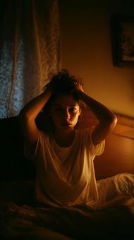夜中に悩み、頭を抱える女性 夜中に悩み、頭を抱える女性の写真