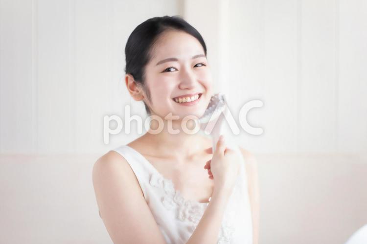 美顔ローラーを使う女性（笑顔） 美顔ローラー,ローラー,顔痩せの写真素材
