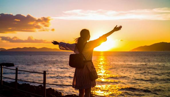夕方に夕日の中を歩く女子高生のシルエット 夕方に夕日の中を歩く女子高生のシルエットの写真