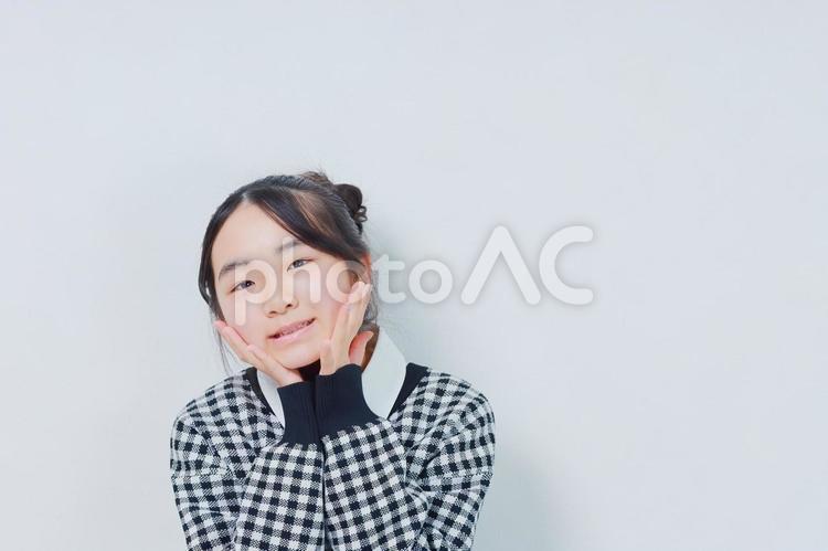 頬に手のひらを当てた笑顔の小学生女子 女性,小学生,少女の写真素材