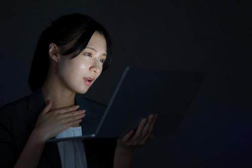 女性がノートPCを見つめるの写真