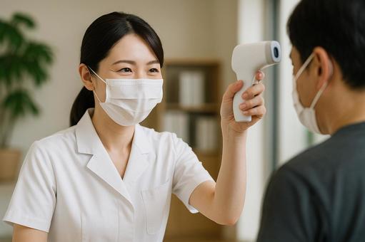 体温測定を行う女性スタッフ 体温測定を行う女性スタッフの写真