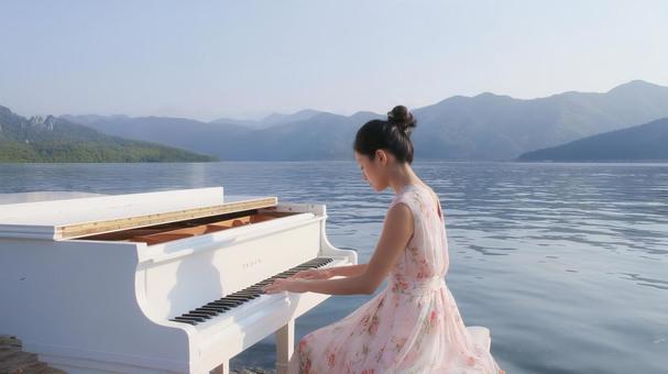 美しい湖畔でピアノを弾く女性 美しい湖畔でピアノを弾く女性の写真