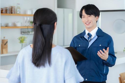 リビングで女性に説明をする不動産業者 リビングで女性に説明をする不動産業者 不動産,設計,女性の写真素材
