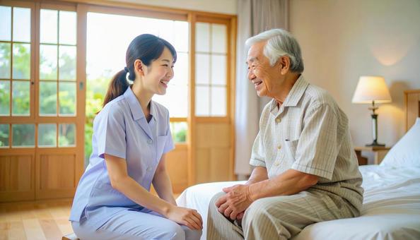 笑顔で話す女性介護士と高齢男性 笑顔で話す女性介護士と高齢男性の写真