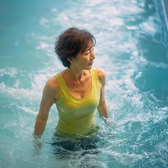 水中運動を楽しむ健康的な高齢女性の写真
