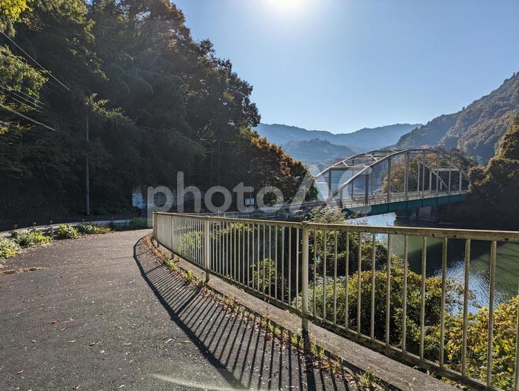 湖かかる橋へと続く道 湖,山,日差しの写真素材