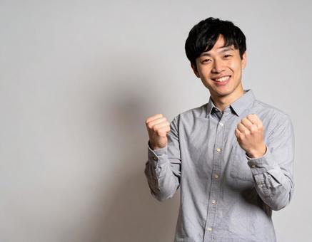 ガッツポーズで喜ぶ若い男性 ガッツポーズで喜ぶ若い男性の写真