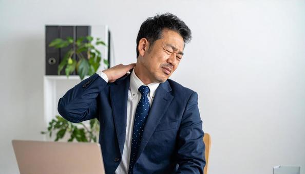 仕事の合間に肩を回すミドルのエンジニア 仕事の合間に肩を回すミドルのエンジニアの写真