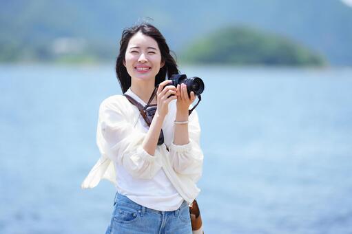 ドライブ先で一眼レフを構える若い女性 女性,カメラ,カメラ女子の写真素材