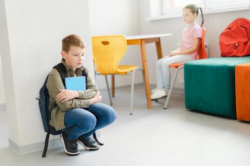 ノートを持ってしゃがむ男の子と椅子に座る女の子 男の子,女の子,子どもの写真素材