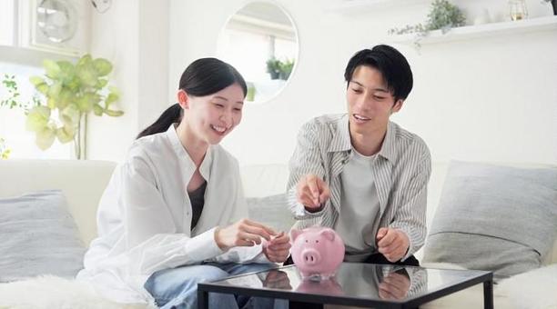 貯金箱にお金を入れるアジア人のカップル 貯金箱にお金を入れるアジア人のカップル 貯金,カップル,女性の写真素材